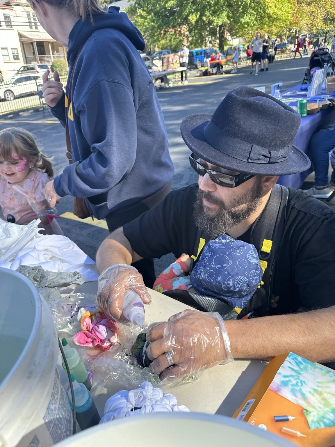 An attendee tying a shirt at the community tie-dye table