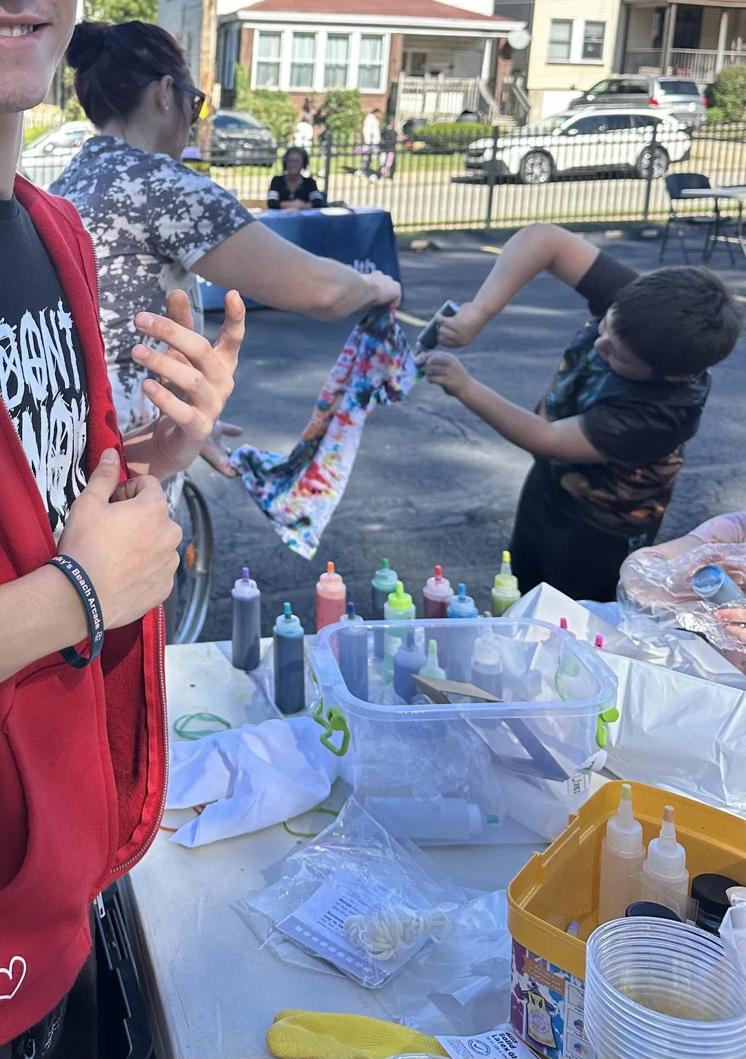 Children and adults creating tie-dye shirts together around the table